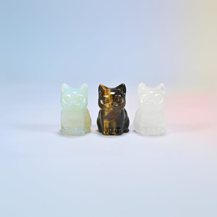 Three 1.5 inch sitting cat crystal carvings in opalite, natural tiger eye and natural clear quartz