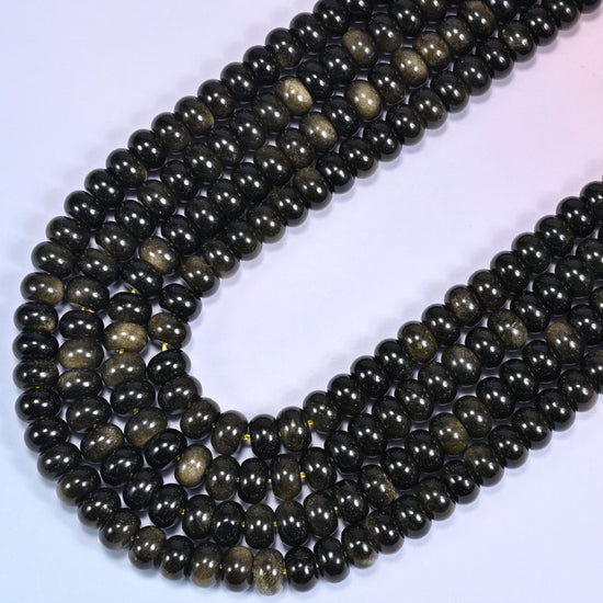 Close-up of Gold Obsidian rondelle beads coiled in a circular arrangement on a lavender background.