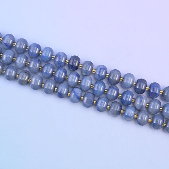 Three strands angled across a pale background, the grooved rondelle profile visible along the whole run