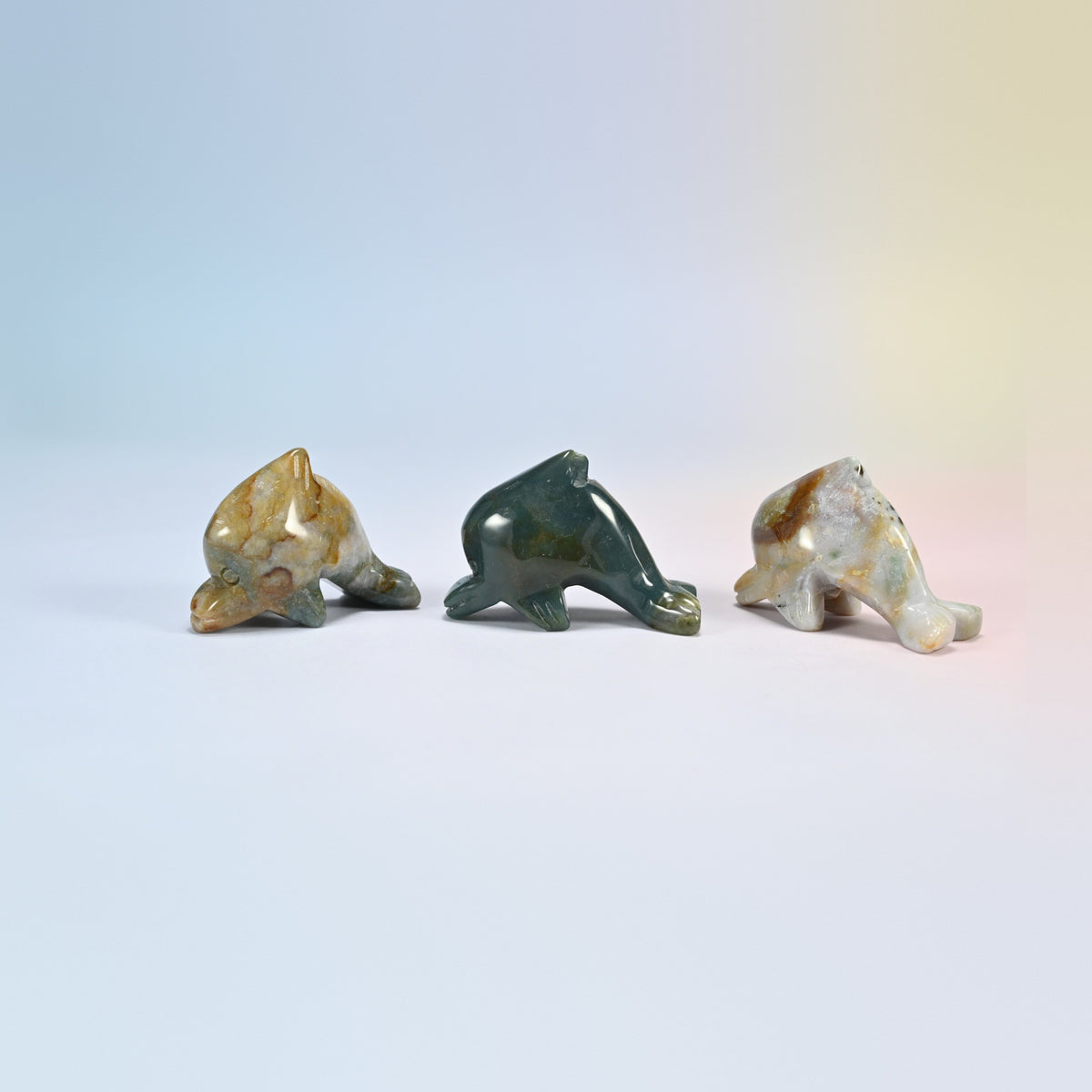 Three Indian agate dolphin crystal carvings, 2 inch, green, tan and cream natural stone