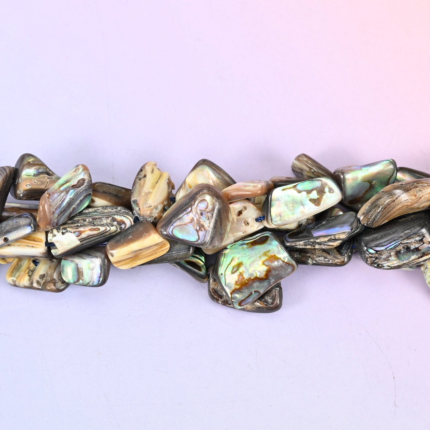 Abalone Shell Freeform Beads — irregular flat slabs cut from abalone shell, polished on one face to bring up the peacock green, blue and silver iridescence over cream and smoky grey.
