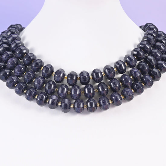 Blue Sandstone pumpkin beads arranged in rows on a white neck display form