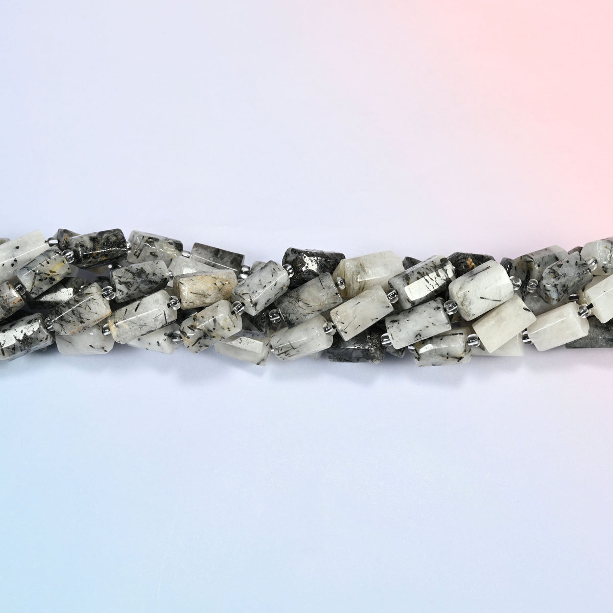 Strands of black rutilated quartz faceted tube beads twisted together in a horizontal row