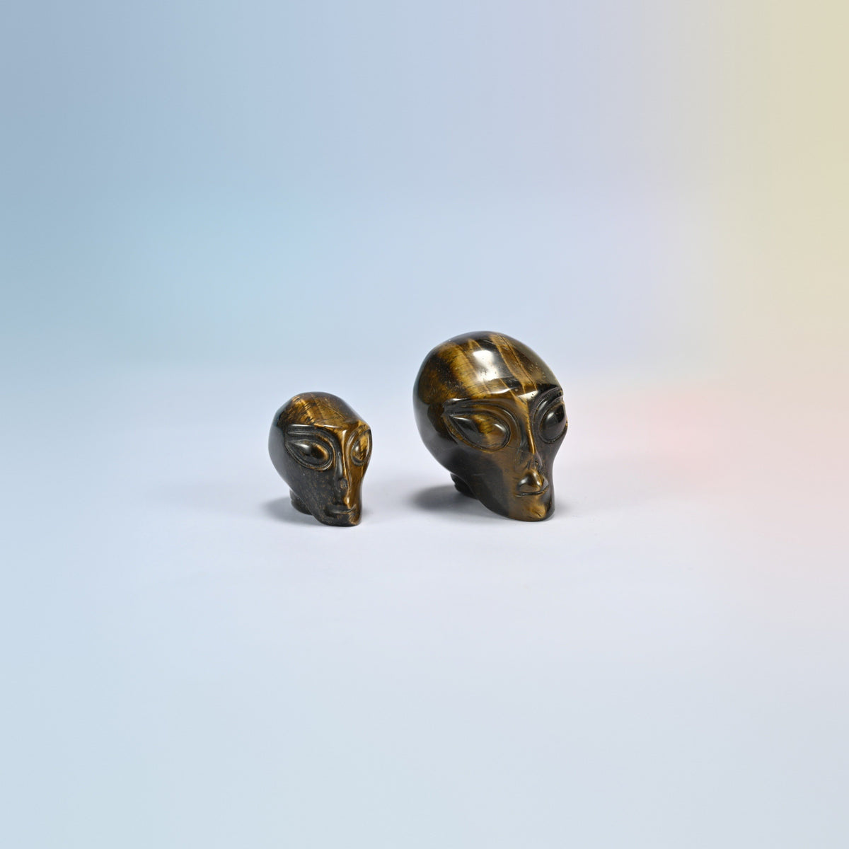 Two tiger eye alien head crystal carvings, 1.5 inch and 2 inch, golden brown natural stone with shimmering bands