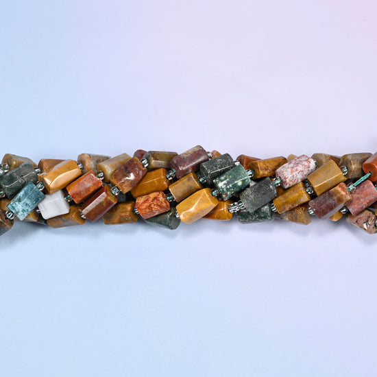 Close-up of coiled Ocean Jasper tube beads with clear glass spacers, showing the natural stone texture and color variation.