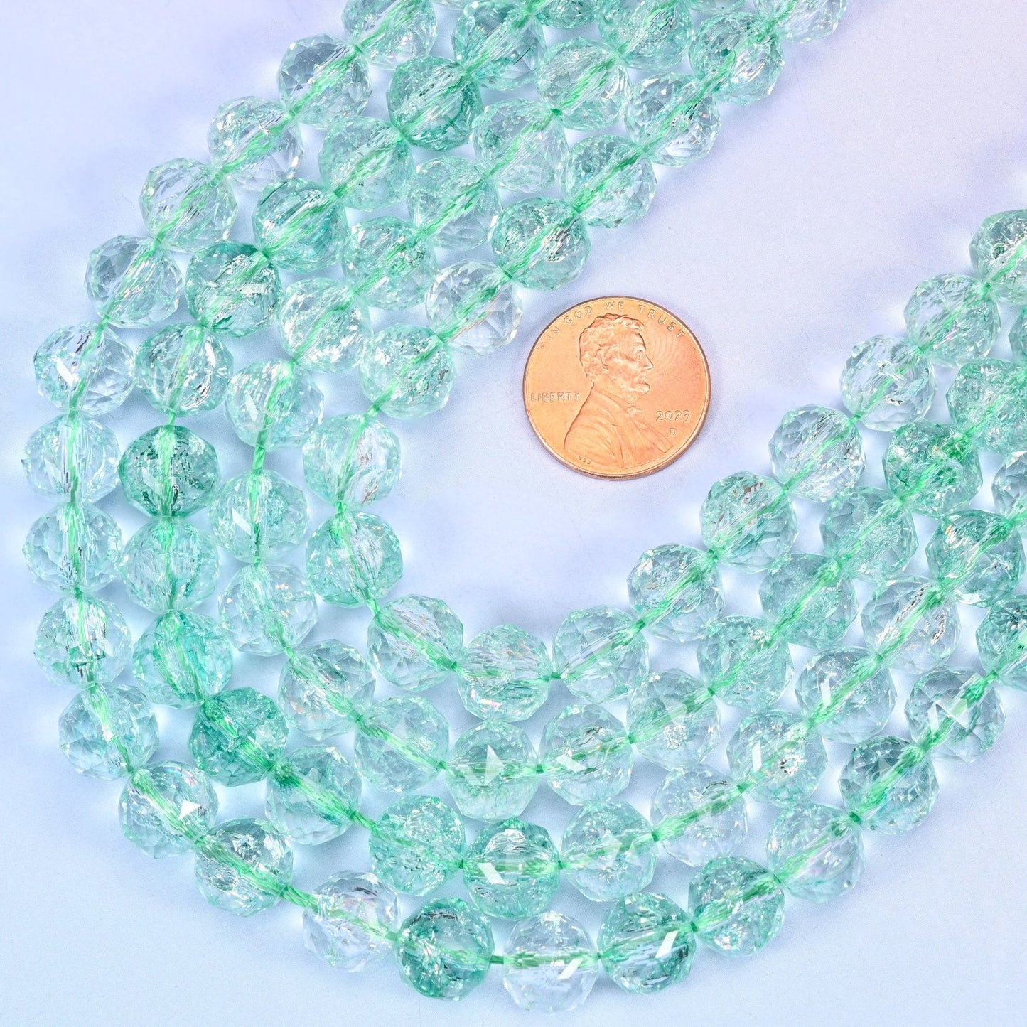 Faceted round cut transparent green glass beads