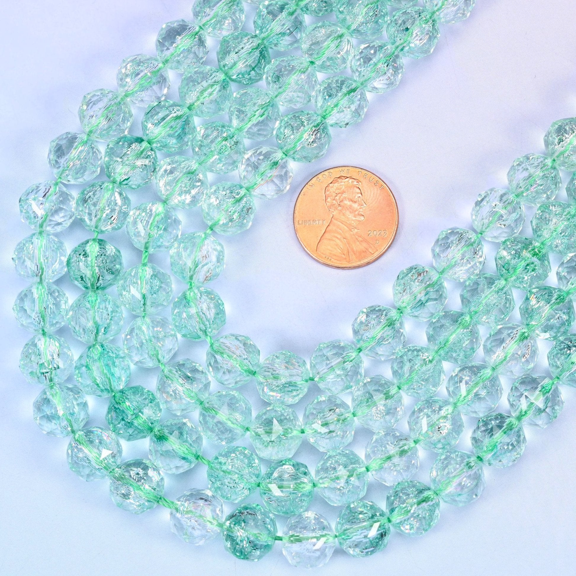 Faceted round cut transparent green glass beads