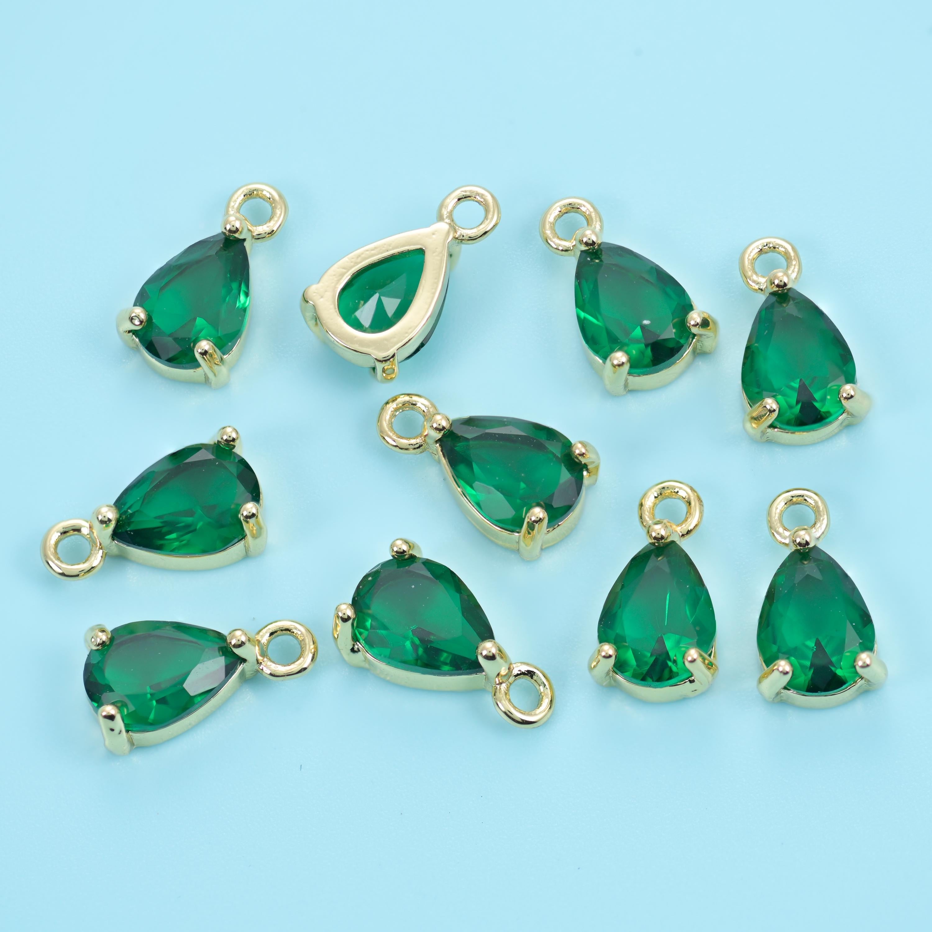 A pear-cut zircon held in a slim gold prong setting with a ring at the point, faceted right through so light passes clean…