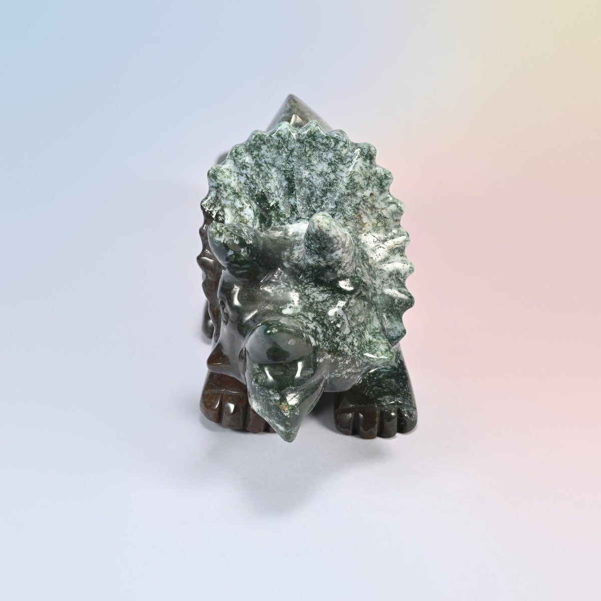 Front view of the Indian agate triceratops head, three horns and a scalloped mossy green frill