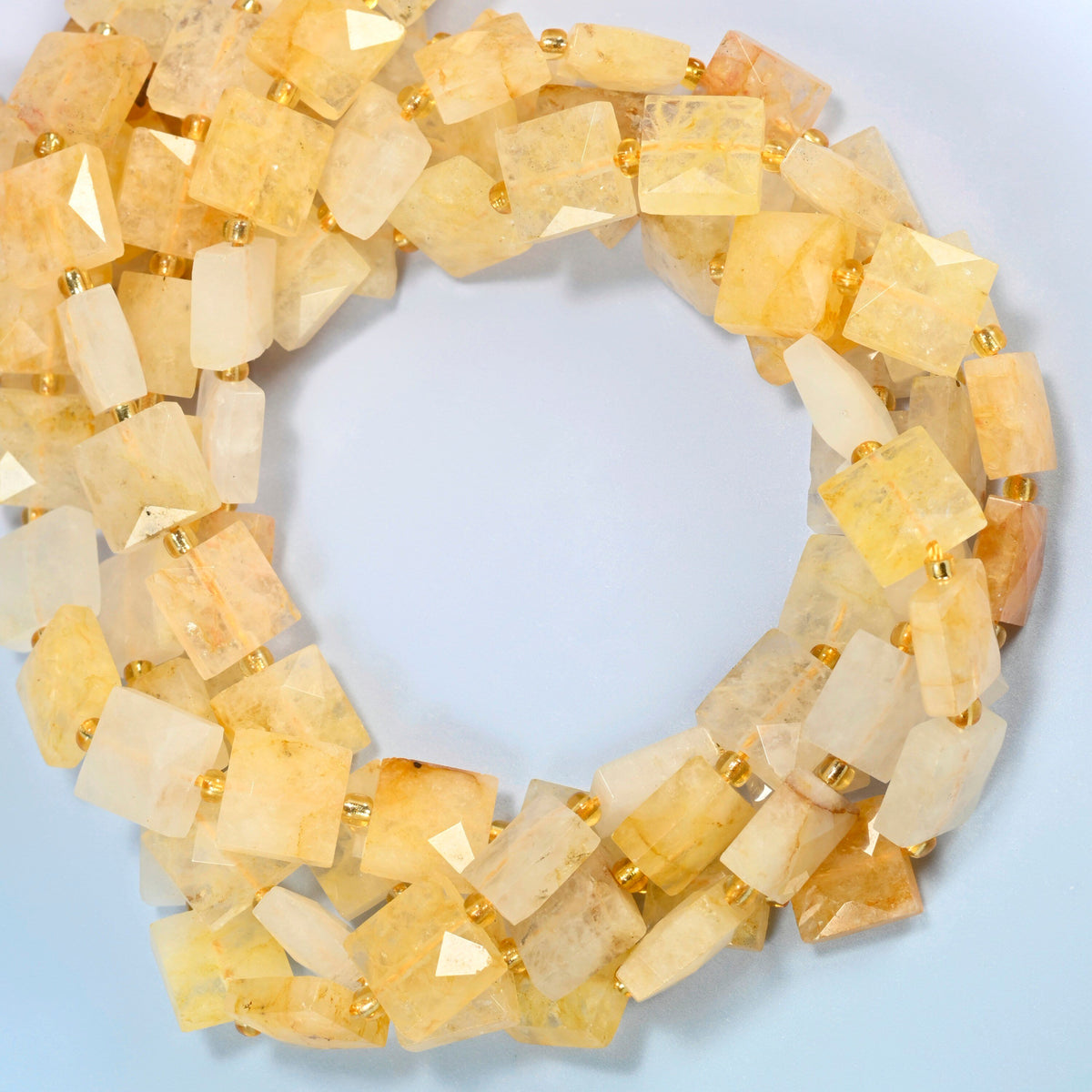 Natural golden healer quartz faceted flat square beads coiled into overlapping loops, whole strands of warm golden stone