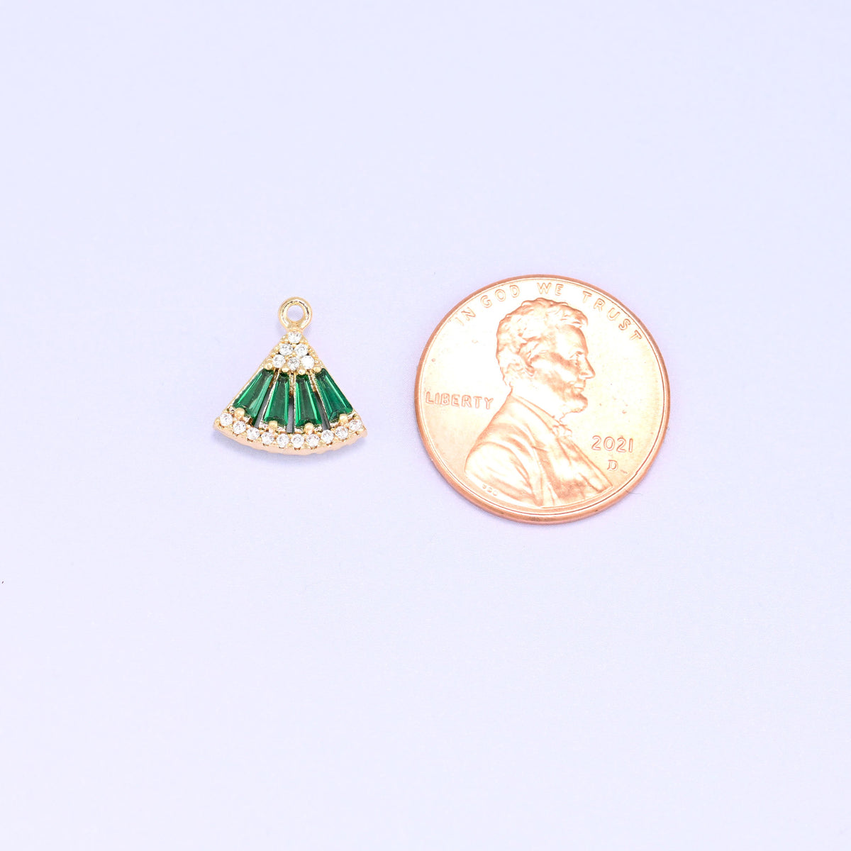 Small gold charms, one green fan charm shown beside a US penny for size