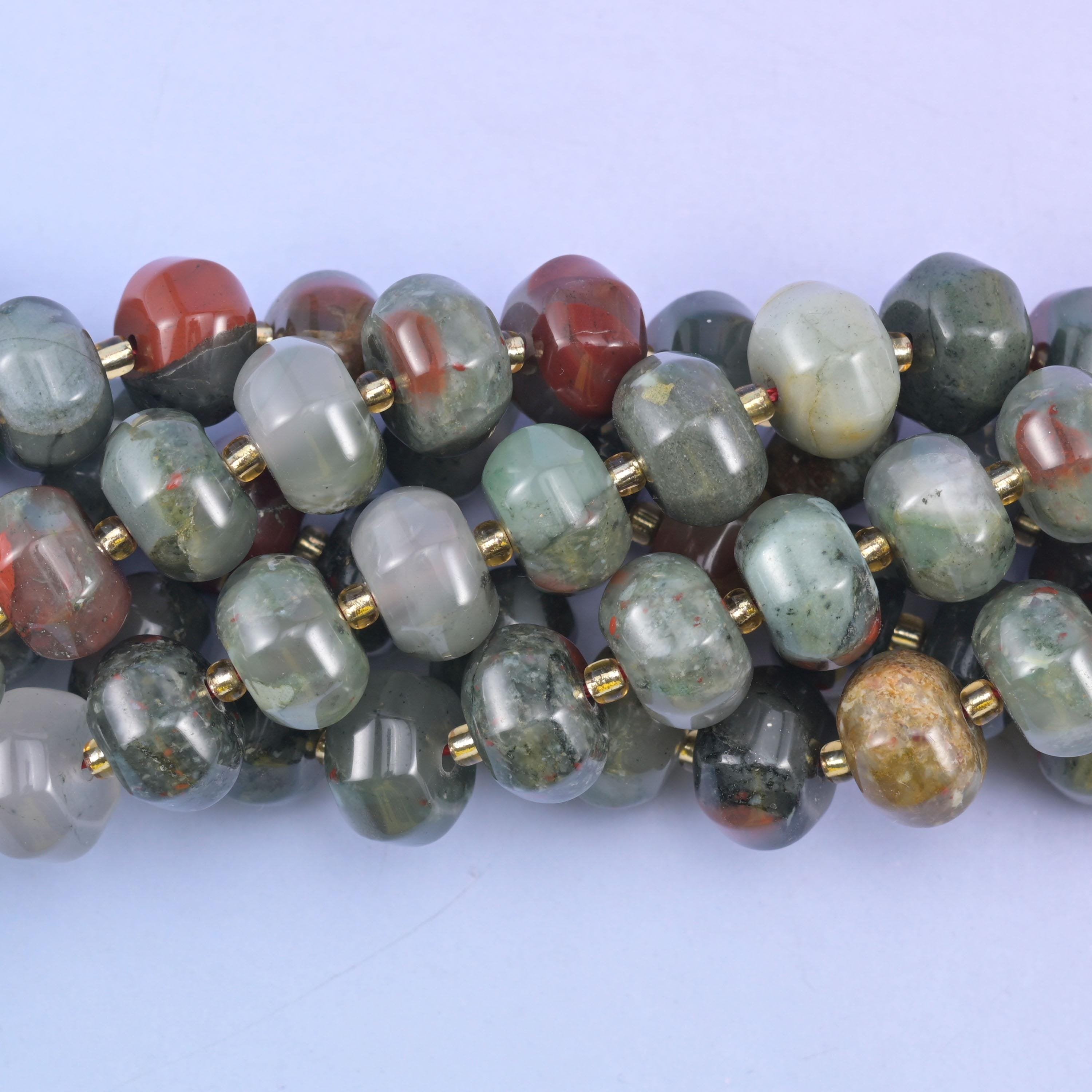 Close macro of african bloodstone pumpkin beads, a deep brick-red bead among the grey-green ones