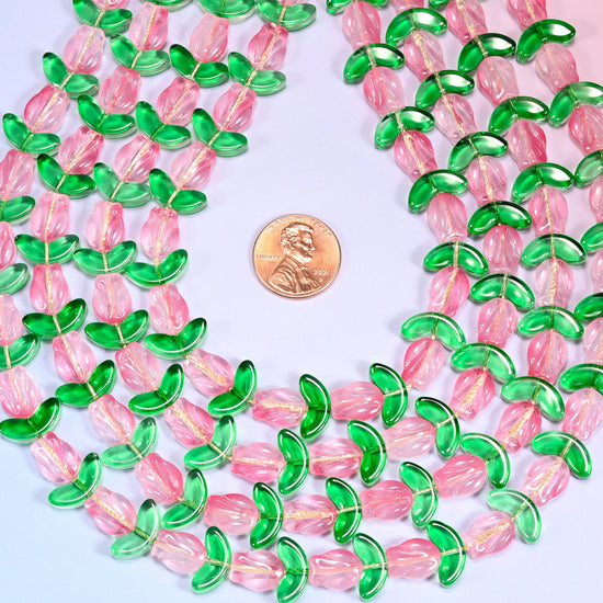 Pink tulip flower-shaped glass beads paired with green leaf-shaped glass beads for botanical-inspired jewelry.