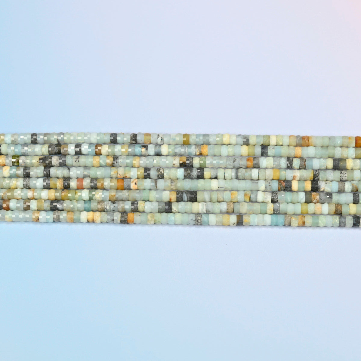 Several strands of multi-color amazonite faceted heishi disc beads laid in straight rows