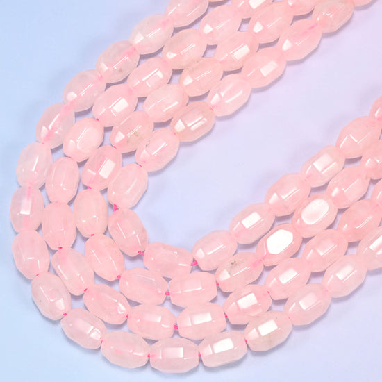 Close-up of a circular coil of Rose Quartz faceted barrel beads on a light blue background.