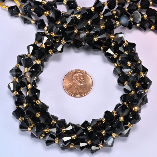 Dyed black strip agate bicone beads coiled into a round ring, 8mm beads with gold-tone spacers throughout.