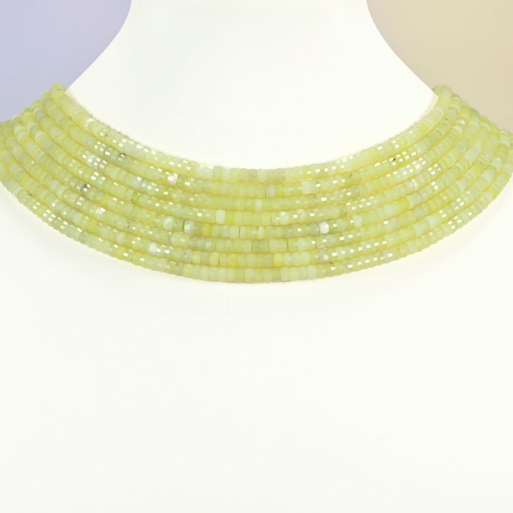 Lemon Jade faceted heishi disc strands arranged as a layered collar on a white display bust, yellow-green beads across the neck