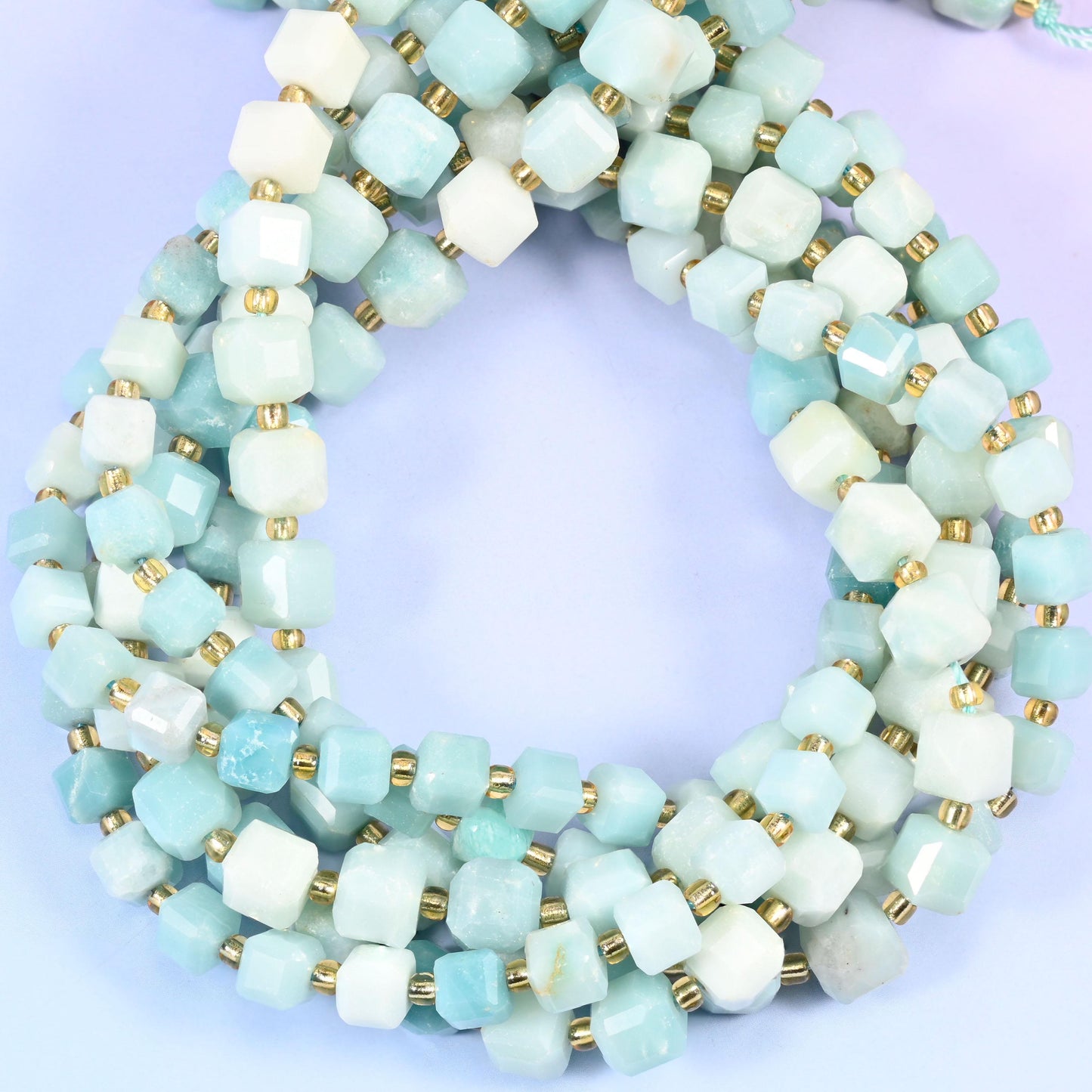 Soft sky blue amazonite clouded with cream and chalky white, cut into cubes with the corners knocked back into facets. Semi-opaque and cool toned