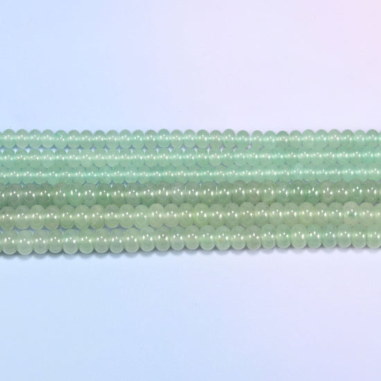 Green Aventurine gemstone rondelle beads in straight rows, showing the flat disc profile and centre drilling