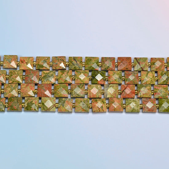Several strands of natural unakite faceted flat square beads laid in straight rows