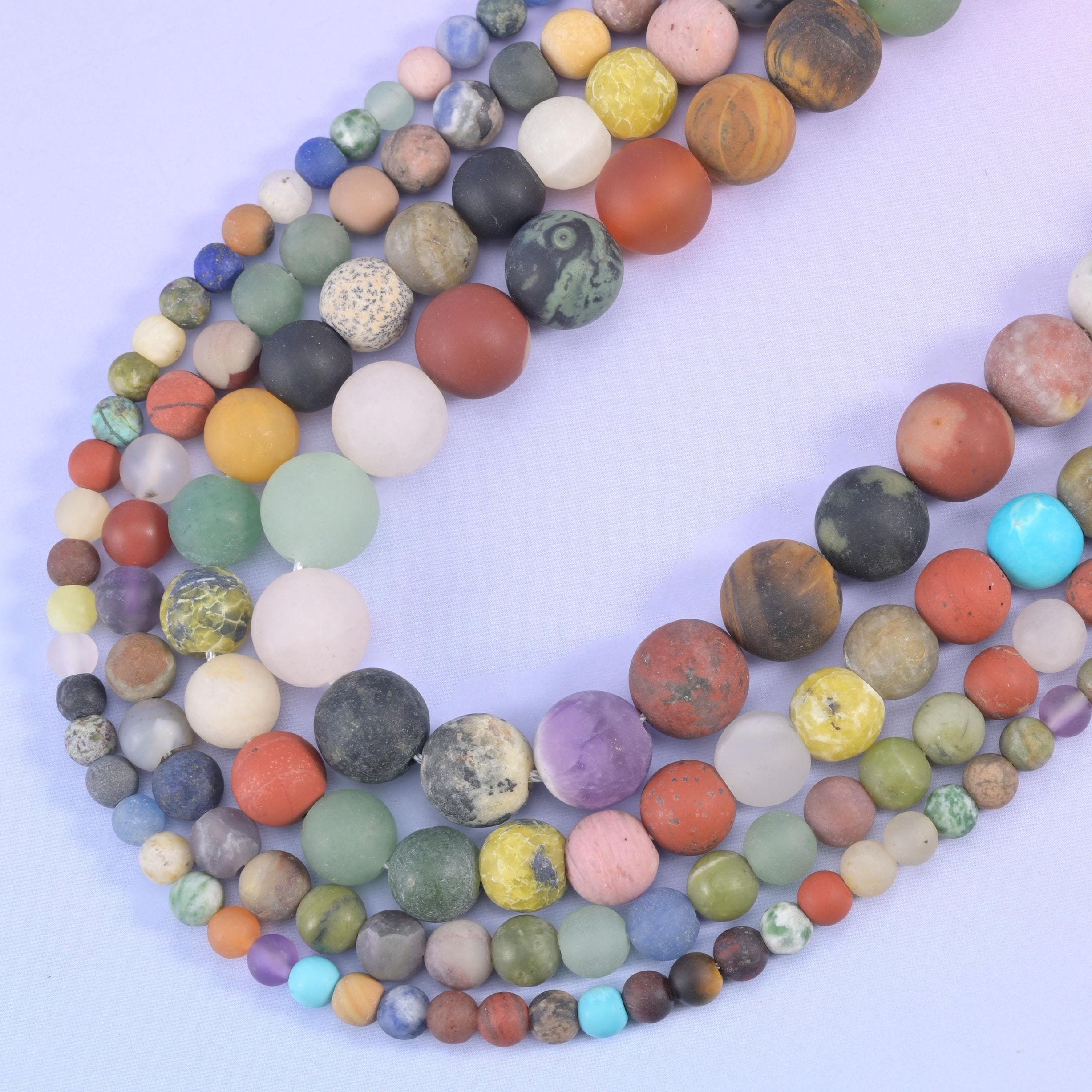 Matte gemstone rounds curving in a V, mixing larger and smaller beads