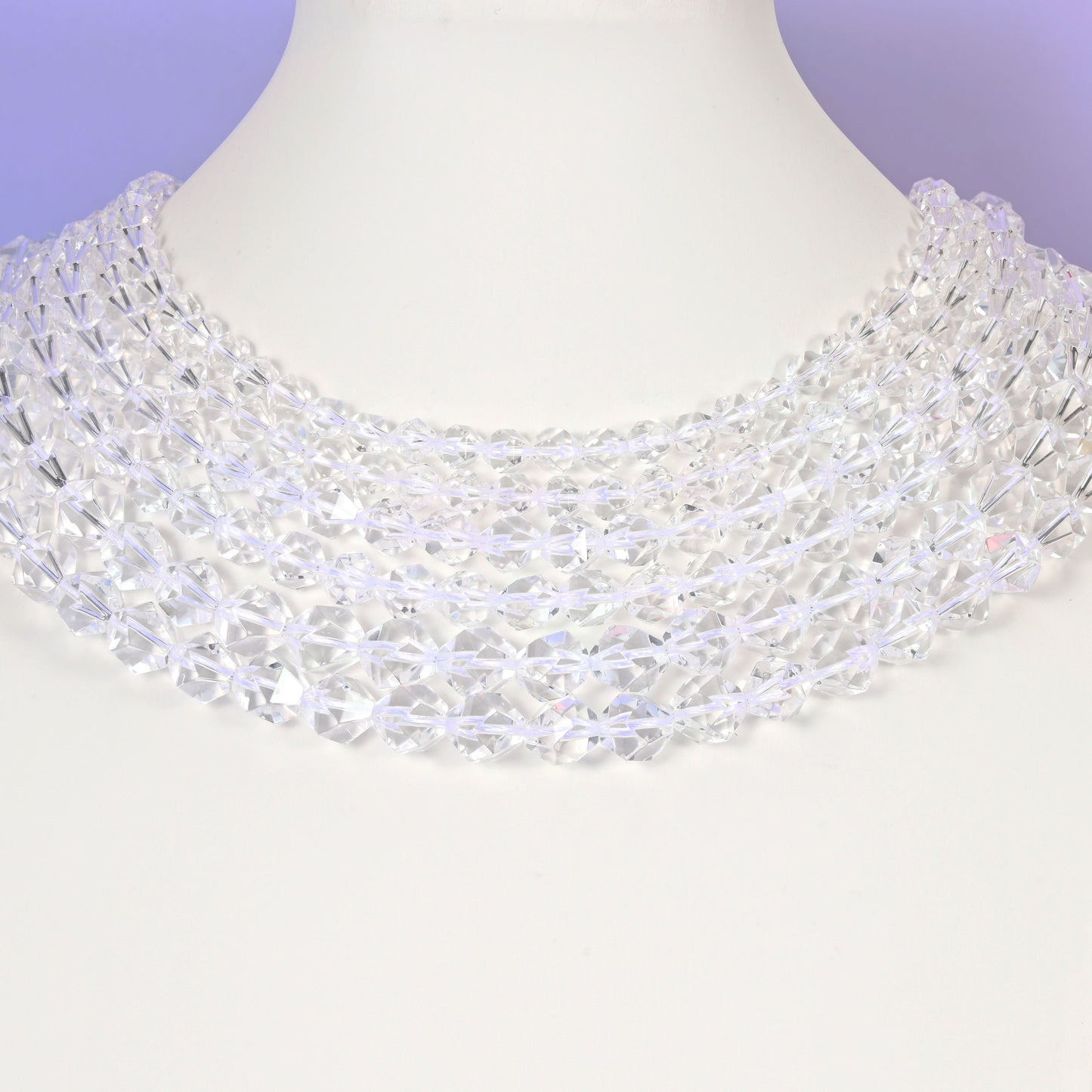 Clear Quartz diamond star cut beads looped over a white display stand, faceted 6mm to 10mm rounds