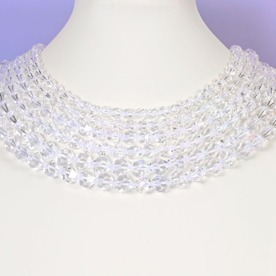 Clear Quartz diamond star cut beads looped over a white display stand, faceted 6mm to 10mm rounds