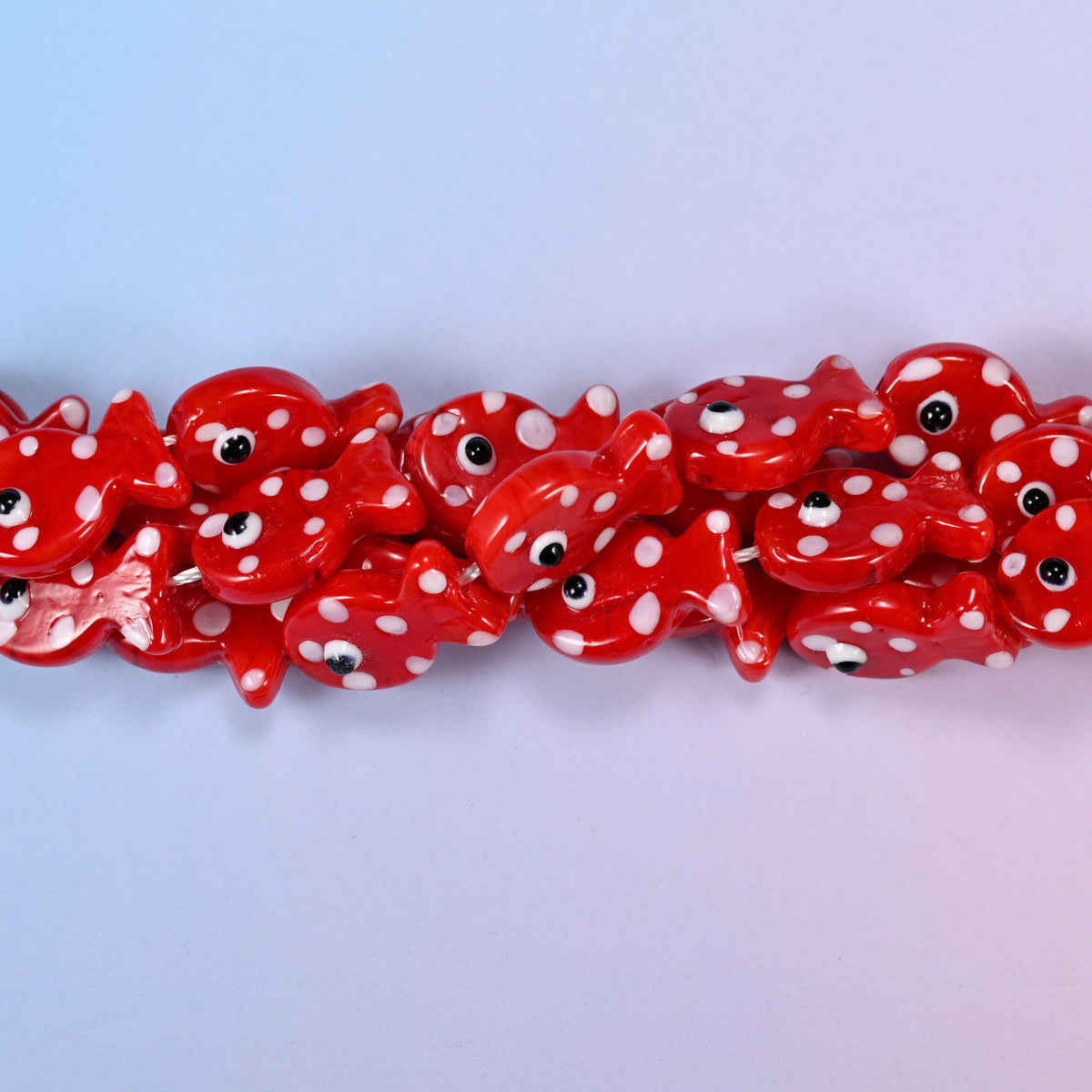 Fish-shaped red glass beads with white dot pattern