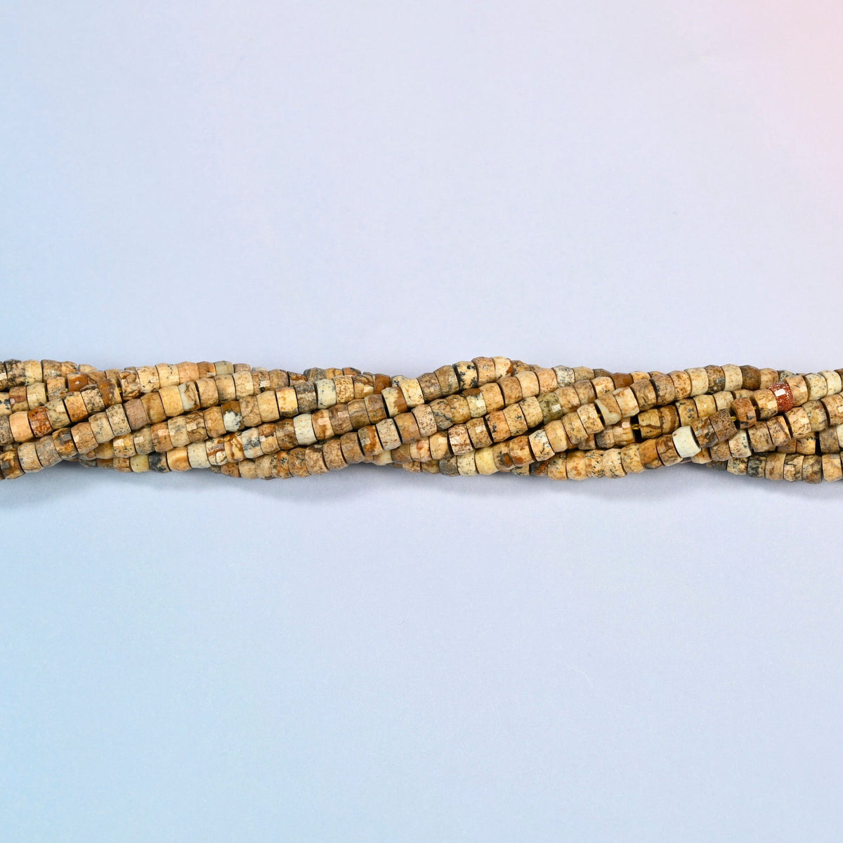 Strands of picture jasper faceted heishi disc beads twisted together in a horizontal row