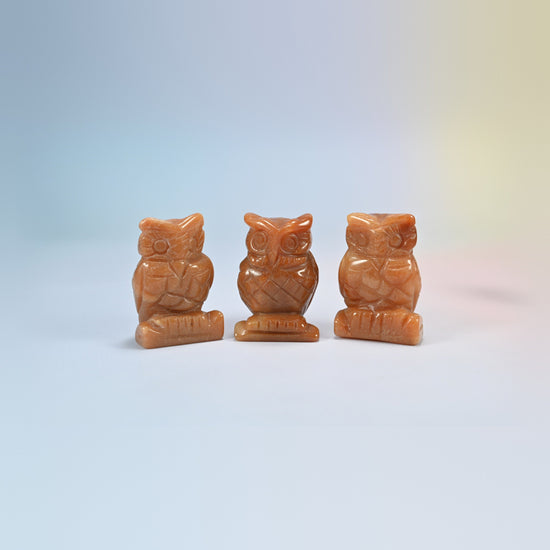 Owl crystal carving in red aventurine, orange-red natural stone with a soft shimmer