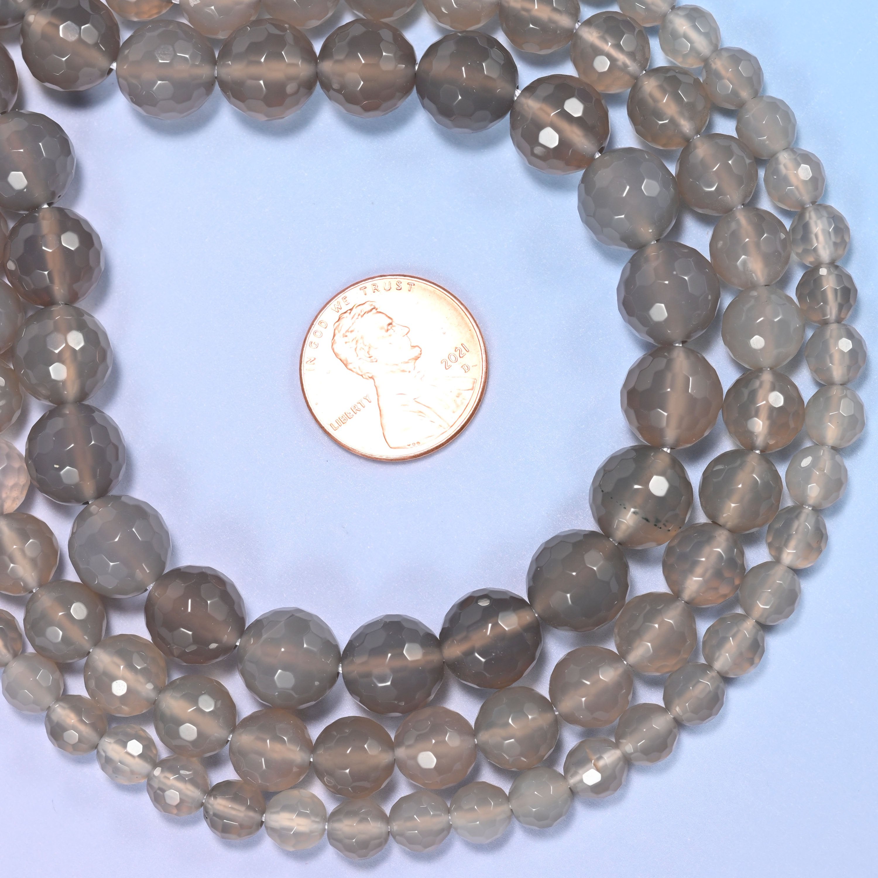 Group of gray agate round beads showing natural color and pattern variation.