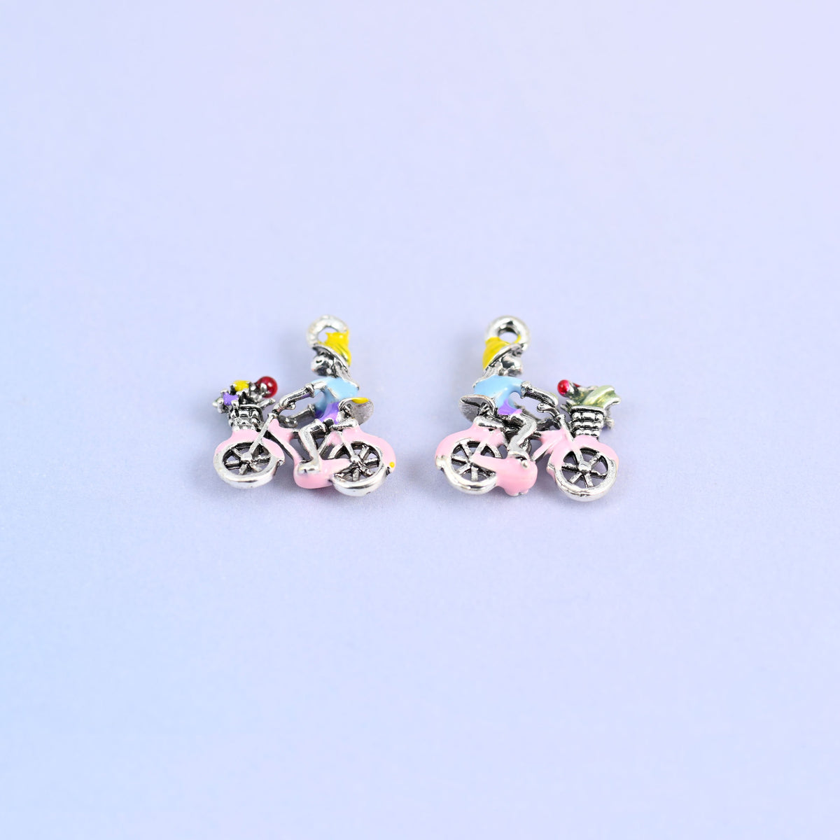 Two bicycle charms angled to show the spoked wheels.