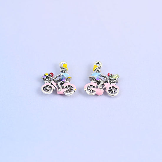 Two bicycle charms angled to show the spoked wheels.