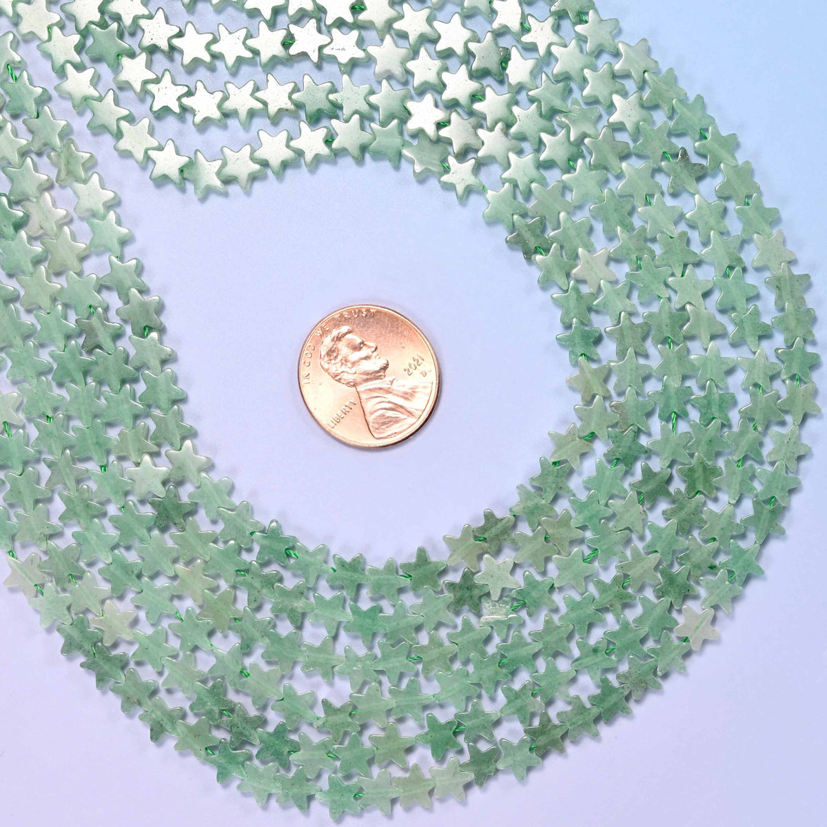 Green aventurine flat star beads in soft sage and mint green, faintly speckled and semi-translucent.
