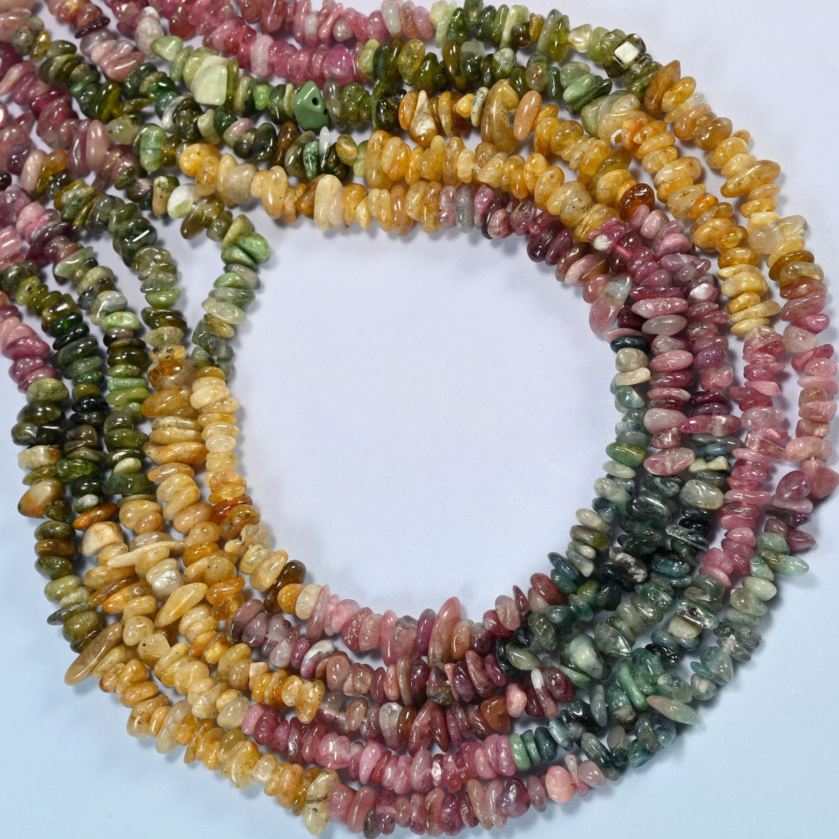 Multicolor tourmaline chip beads curved into an open loop, golden yellow, pink and dark green chips