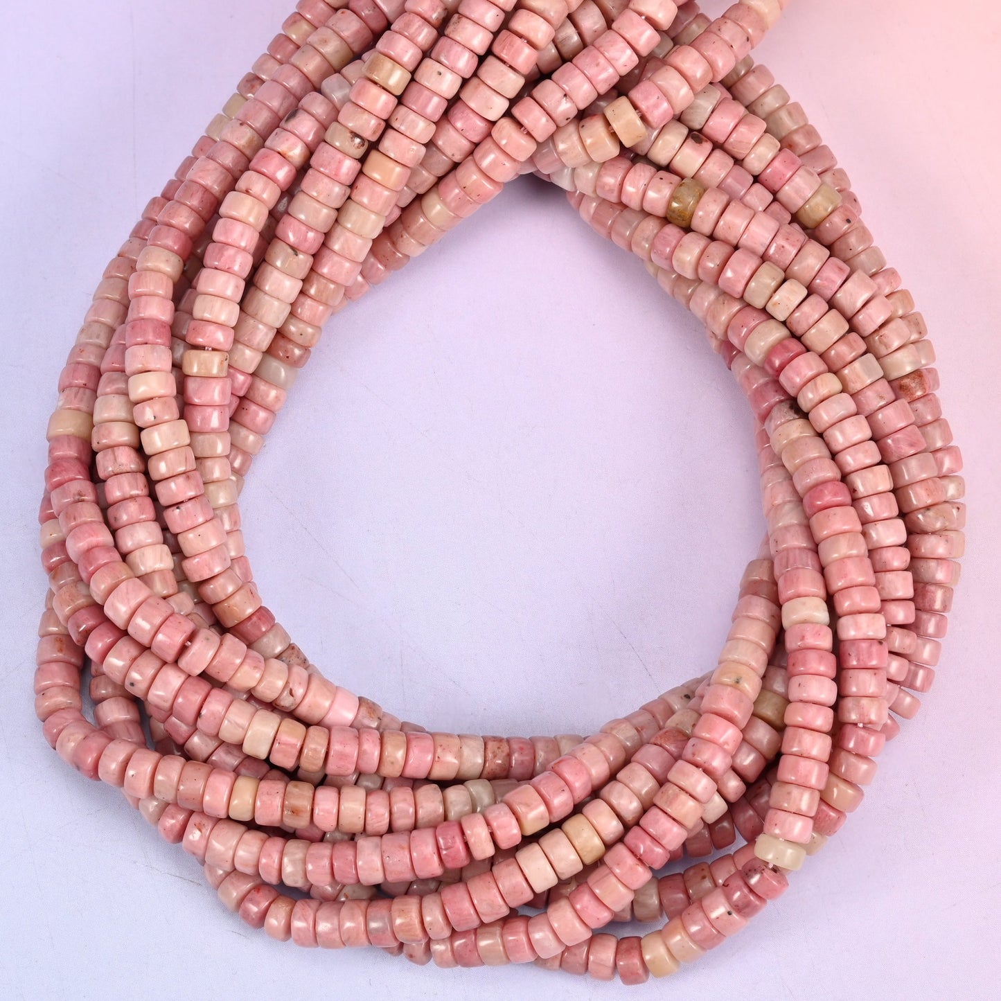 Pink Rhodonite heishi beads, natural pink tone shifts from soft blush to deeper rose.