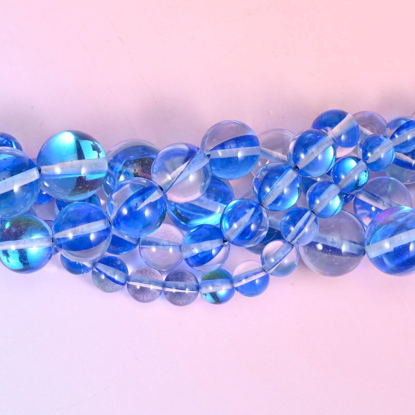 Translucent cornflower blue glass rounds with a glassy clear core and a shimmering aurora coating