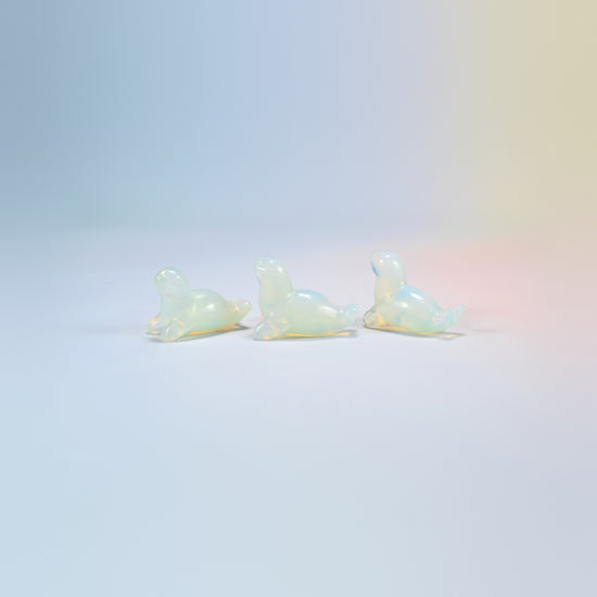 Three opalite sea lion crystal carvings, 1.5 inch, glowing milky white man-made glass