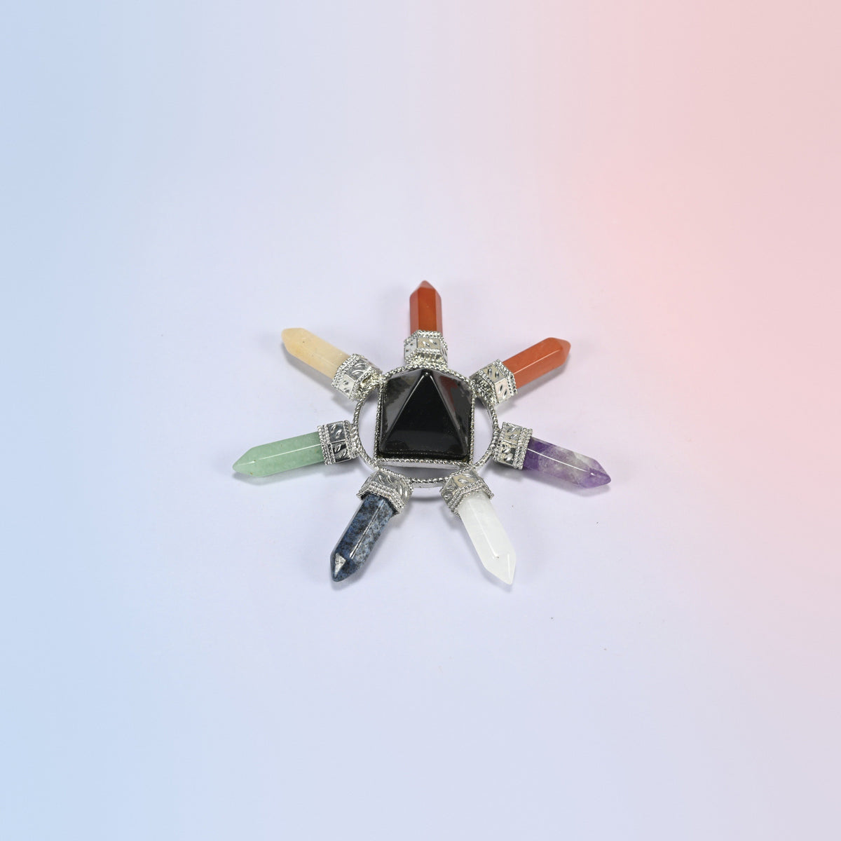 Crystal energy generator with a glossy black obsidian pyramid and seven chakra crystal points in a silver-tone frame