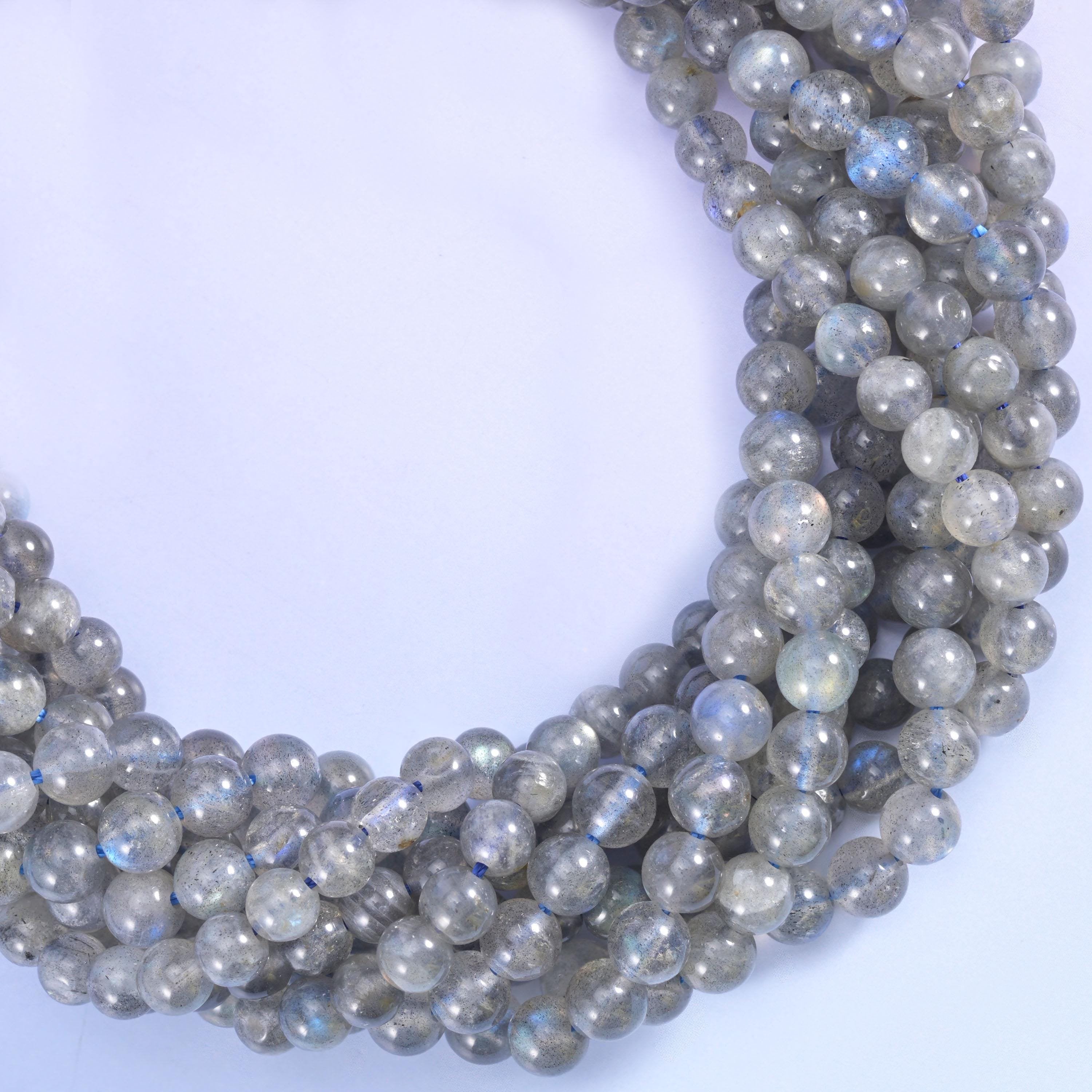 Pale smoky grey and semi-translucent, flashing cool blue where the crystal planes catch the light