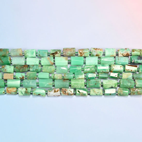 Several strands of Australian jade faceted tube beads laid in straight rows with light green seed bead spacers