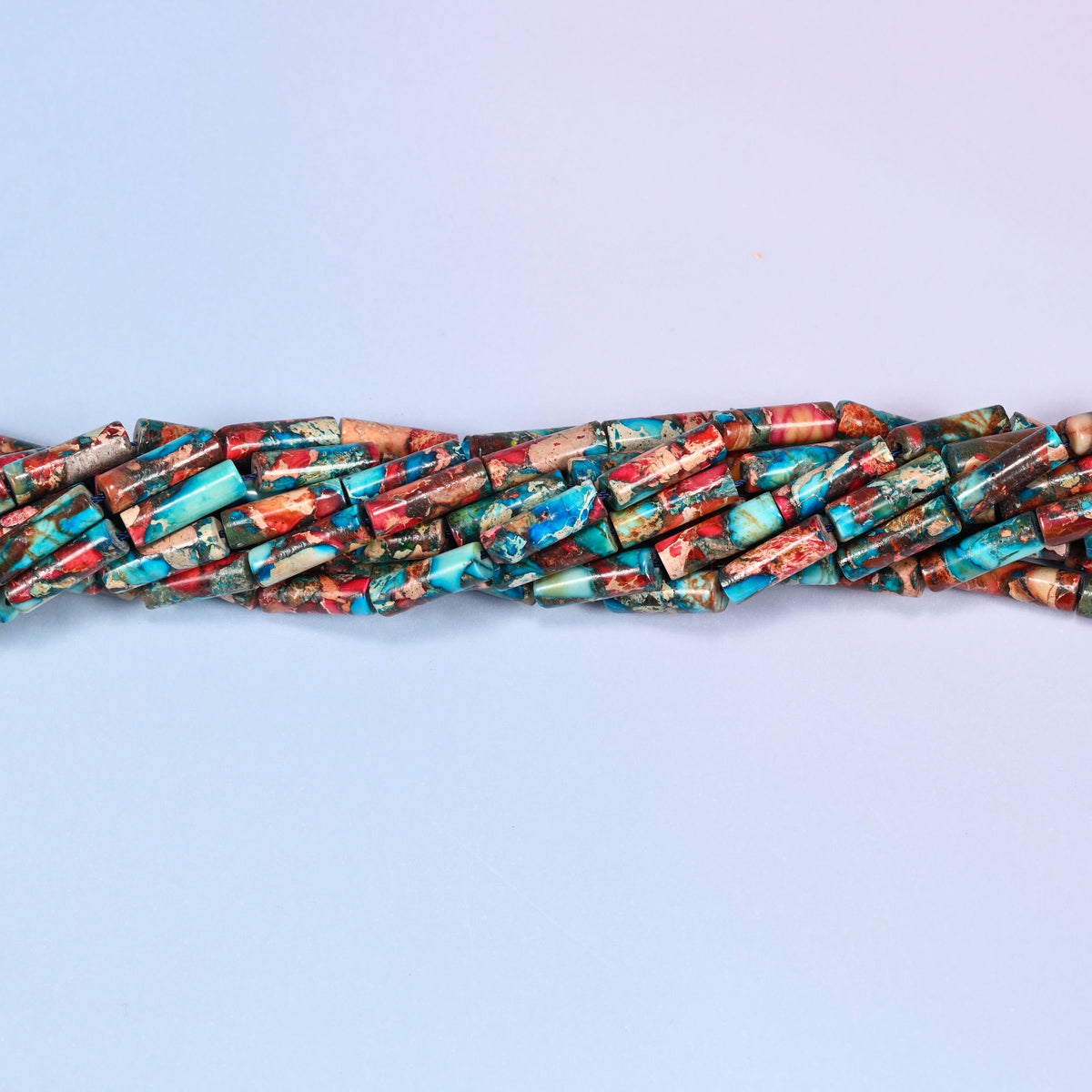 Multicolor Sea Sediment Jasper tube beads featuring turquoise, coral red, rust brown and tan over a mineral-veined base.