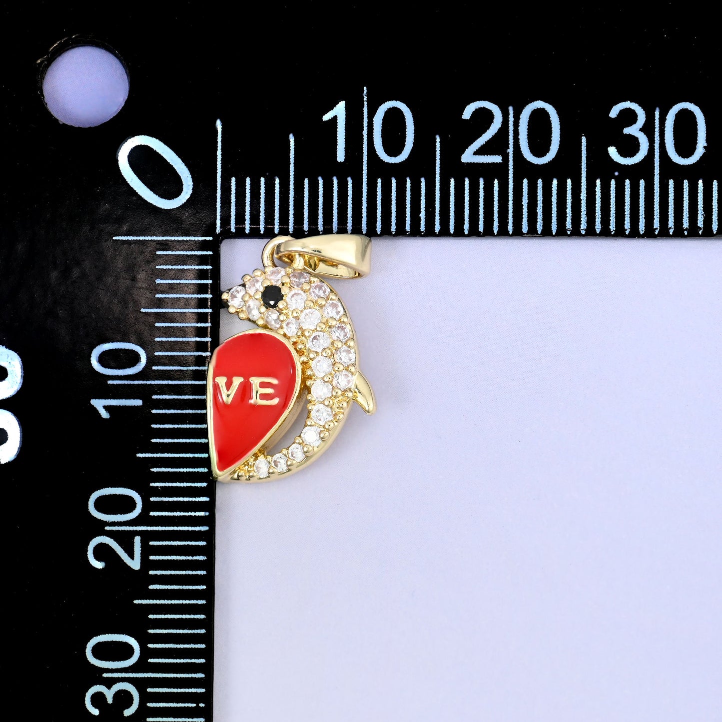 Leaping dolphin curled around a red enamel heart lettered LOVE, set with clear zircon and pale blue enamel