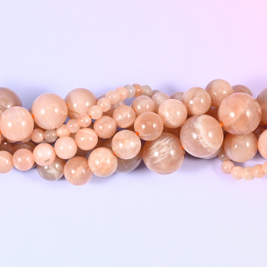Peach Moonstone Smooth Round Beads, approximately 92 beads at 4mm and 32 at 12mm per strand.