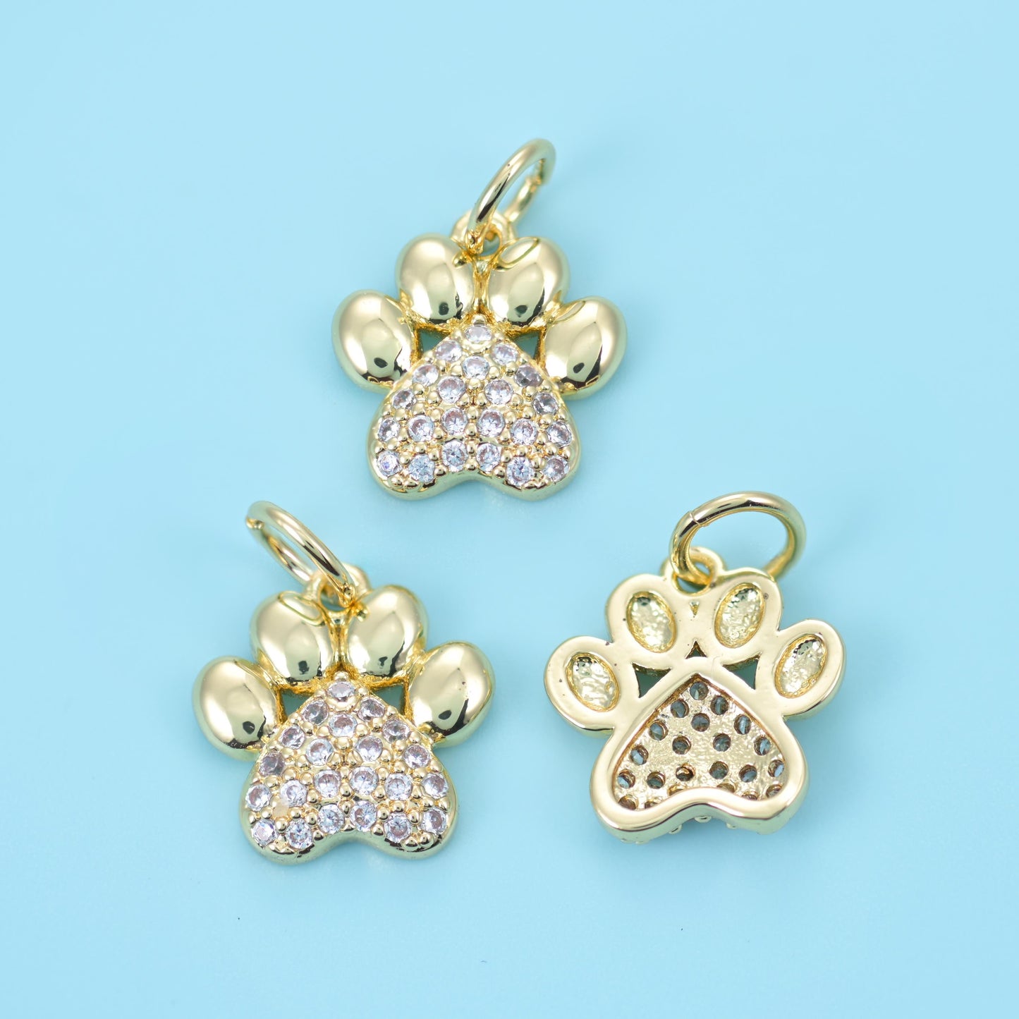 Four smooth polished toe pads above a main pad set with tiny pave clear zircon stones, all on an 18K gold filled brass body…