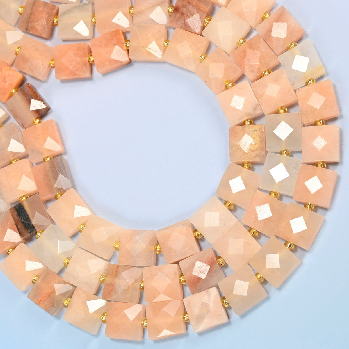 Natural pink aventurine faceted flat square beads curved into an open loop, light peach pink and soft beige beads