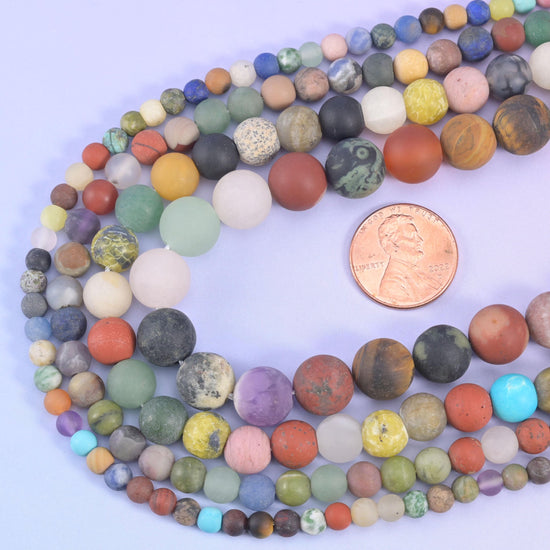 Assorted matte round beads looped around a US penny for size comparison
