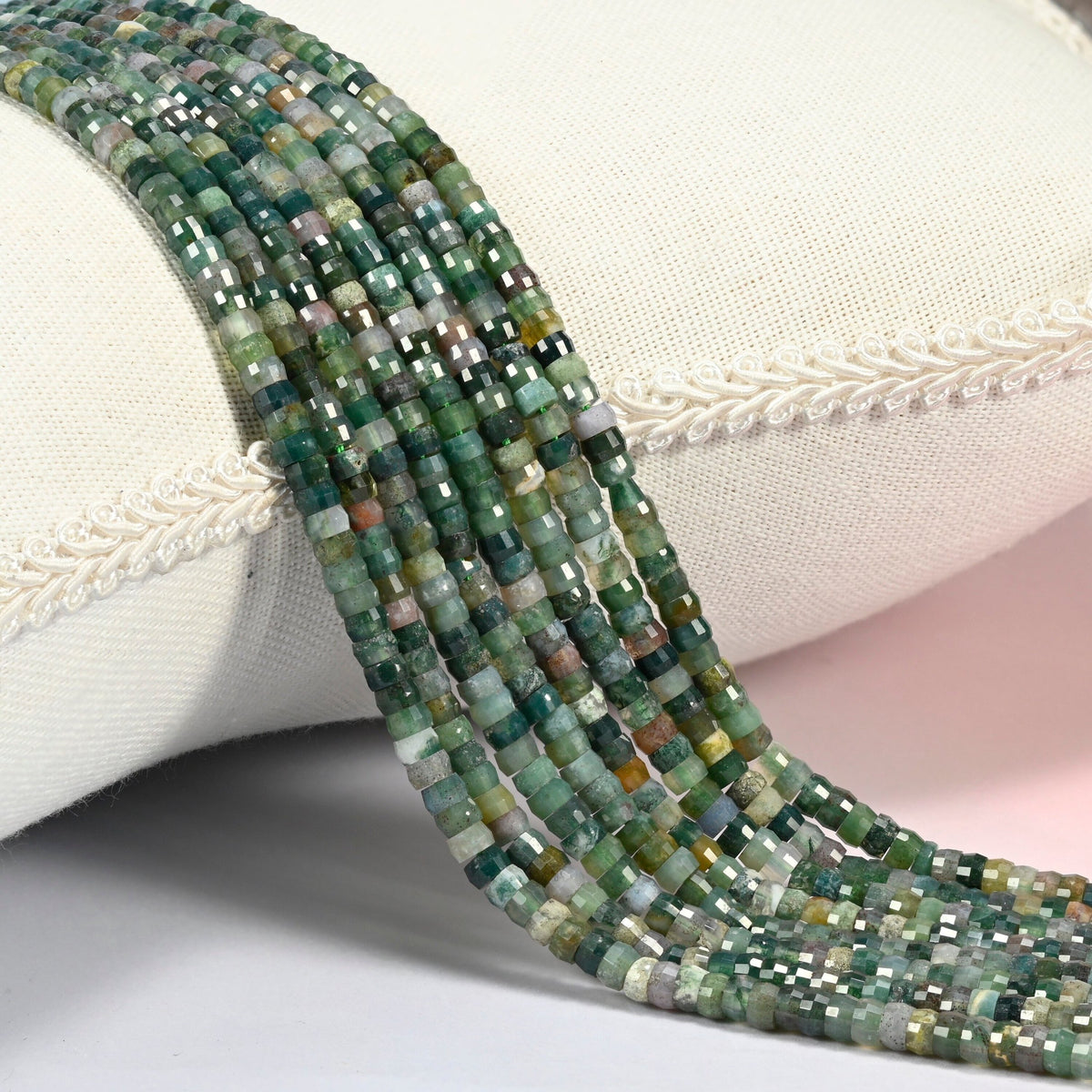 Indian agate faceted heishi disc beads 2x4mm, several strands draped over a white cushion