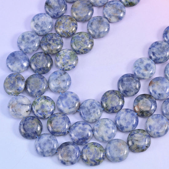Side view of blue spot jasper discs revealing the flat coin profile and centre drill holes