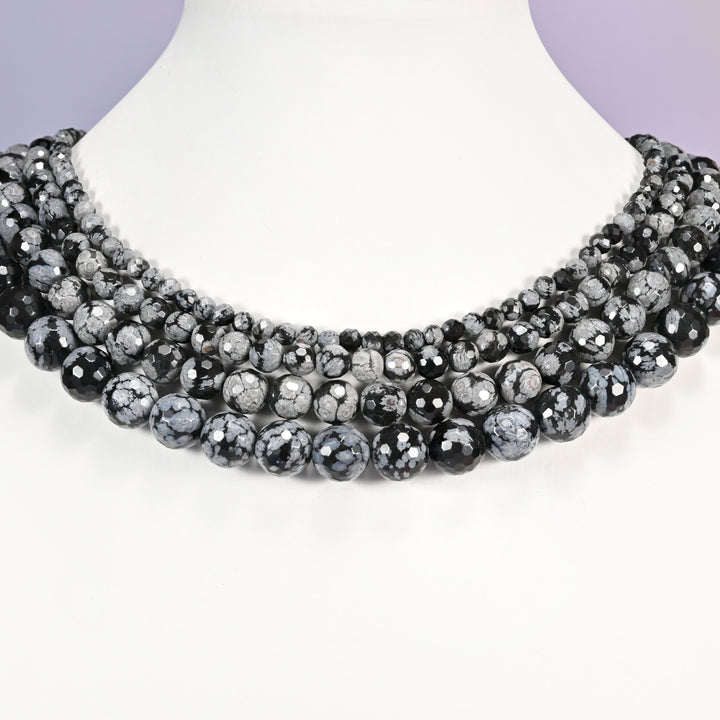 Snowflake Jasper faceted round bead strands in graduating sizes displayed around a white necklace bust against a lavender background.